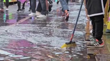 Guatemala, Guatemala, 18 Ağustos 2024. Suyu süpürgeyle temizleyen kişi.