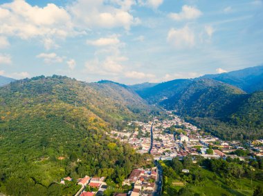 Guatemala 'da dağlarla ve tepelerle çevrili bir köyün hava görüntüsü..