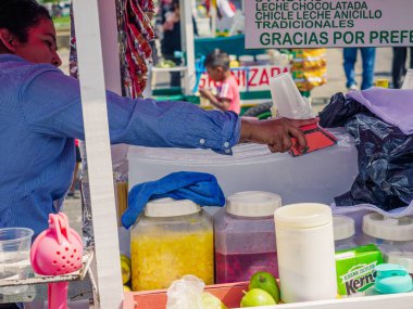 Guatemala, Guatemala / Guatemala-19 Nisan 2023: Bir sokak satıcısı mevsimlik doğal aromalı bir buzlu tıraş hazırlıyor.