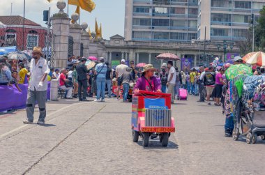 Guatemala, Guatemala / Guatemala-09 Nisan 2023: Mayalı bir kız ev yapımı dondurma satıyor. Onun zanaatkar dondurma arabası toplu taşıma otobüsünün minyatür bir kopyası..
