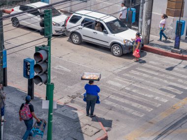 Guatemala, Guatemala-Guatemala, 12 Nisan 2023: Tatlı börek satan bir kadın caddeyi geçmek için kaldırımda bekliyor.