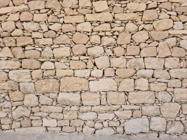 Riyad, Suudi Arabistan 'da düzensiz bir kireç taşı duvar dokusu arka planının yakın plan fotoğrafı