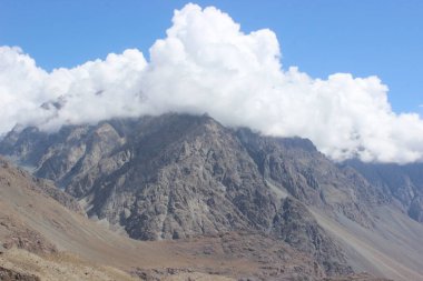   beautiful view of a mountains and white flufy clouds
