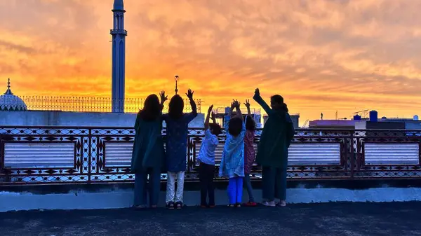 Çocuklar yağmurdan sonra güneşin batışının tadını çıkarıyorlar 