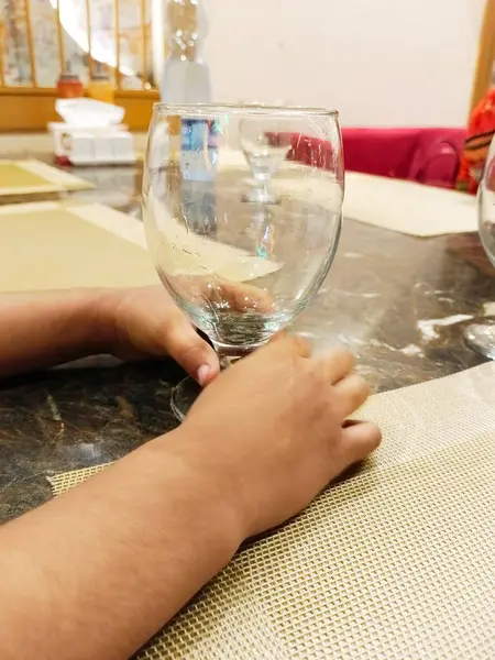 Küçük çocuk elinde boş su bardağı tutuyor 