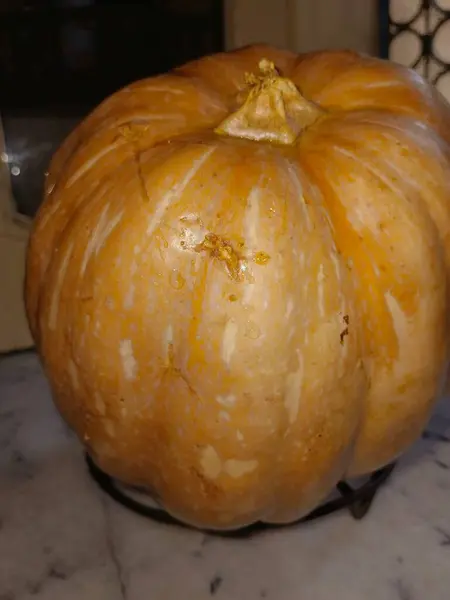 İkiye bölünmüş bir balkabağı parlak turuncu derisini gösterir. Ortadaki çekirdekleri ve yumuşak iplik parçalarını da görebilirsiniz..