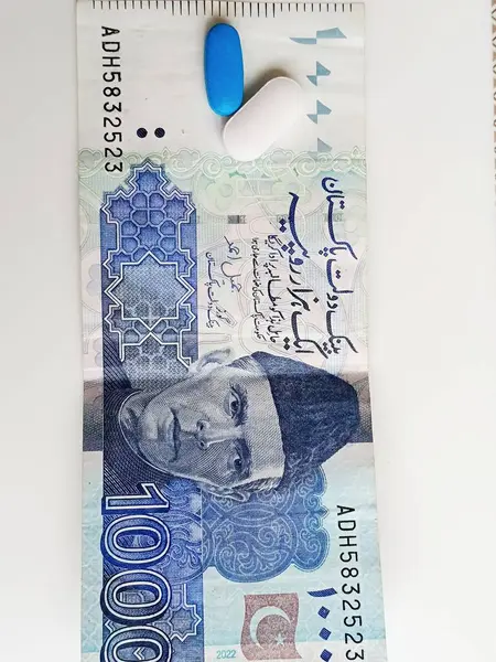 Beyaz ve mavi bir ilaç 1000 rupi 'ye yerleştiriliyor. Not ilacın altında düz bir şekilde duruyor. Basit ama anlaşılır görünüyor.