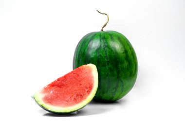Önünde bir dilim kesilmiş taze karpuz, sulu kırmızı et ve yeşil kabuğu gösteriyor, beyaz arka planda izole. Yaz için ideal, yiyecek ve sağlık kavramları.