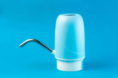 Mavi arka planda paslanmaz çelik borusu olan bir su makinesi pompası. Şişelenmiş su için taşınabilir elektrik pompası, ev, ofis ve açık hava kullanımı için elverişli.