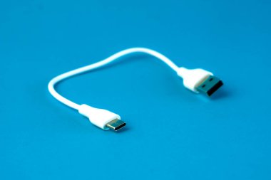 Mavi arka planda mikro-USB kablosu olan kısa beyaz bir USB. Akıllı telefonlar, tabletler ve elektronik cihazlar için şarj ve veri transferi için ideal. Günlük kullanım için küçük ve taşınabilir.