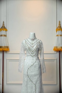 Zarif dantel desenli, renkli boncuk zincirli, Endonezya düğün moda kültürünü sergilemek için ideal bir manken üzerine mükemmel uyan lüks bir beyaz gelinlik..