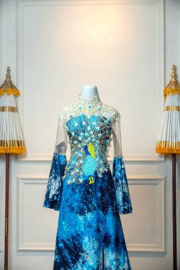 Bir insan eli, hala sarmaşığa bağlı olan olgunlaşmış domates kümesini tutar. Canlı meyveler güneş ışığı altında ışıldar. Bakımı, büyümeyi ve tazeliği simgeler.