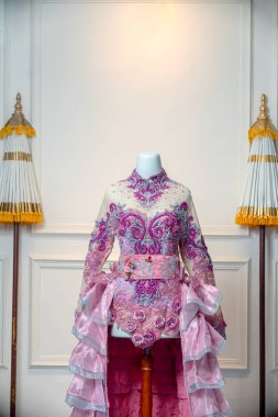 Zarif, pembe bir gelinlik. Detaylı işlemeli, ışıltılı boncuk işlemeli ve katmanlı fırfırlarla süslenmiş. Zarif gelin kutlamaları için lüks ve kadınsı bir tasarım sergiliyor..