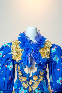 Bir insan eli, hala sarmaşığa bağlı olan olgunlaşmış domates kümesini tutar. Canlı meyveler güneş ışığı altında ışıldar. Bakımı, büyümeyi ve tazeliği simgeler.