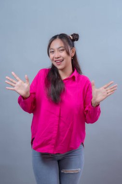 Uzun saçlı, kısa saçlı, neşeli, pembe gömlekli, yırtık pantolonlu, uzun saçlı, neşeli, Endonezyalı genç bir Asyalı kadın..