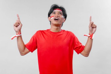 Genç Endonezyalı bir adam Bağımsızlık Günü 'nü gururla kutluyor. Kırmızı giysi, yüz boyası ve anlamlı vatansever bir jestle..