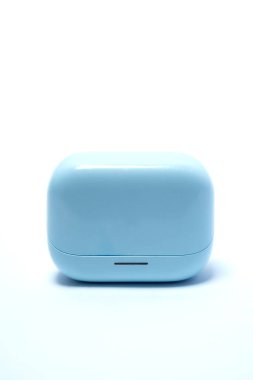 Minimalist mavi kablosuz kulaklıklar beyaz arka planda kapanıyor, dijital yaşam tarzını, modern ses teknolojisini, taşınabilir sesi ve şık elektronik aksesuarları sembolize ediyor..