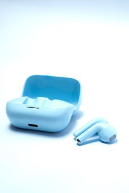 Açık arkaplan üzerine yerleştirilmiş mavi kablosuz kulaklıklar modern yaşam tarzı, taşınabilir ses, müzik keyfi, dijital bağlantı ve şık teknoloji aygıtlarını temsil ediyor..