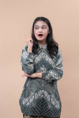 Geleneksel batik kıyafetler giyen Asyalı kadın, fikri, yaratıcılığı, özgüveni ve iş konsepti için ilham verici bir görünüm sergiliyor..