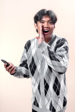 Akıllı telefonu elinde tutan Asyalı bir adam, el hareketleriyle iletişim, heyecan ve iş hayatı, yaşam tarzı ve reklam için kendine güveni sembolize ediyor..