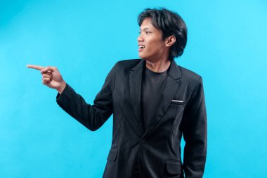 Siyah takım elbiseli genç bir Asyalı gülümseyen bir yüzü, kendine güveni ve olumlu jesti, başarıyı, yönü ve profesyonel tutumu simgeleyen bir tarafı işaret ediyor..