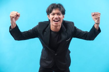 Siyah takım elbiseli neşeli bir genç adam kendine güvenerek gülümsüyor zafer, hırs ve pozitif enerjiyi ifade ediyor iş, kariyer ve motivasyon kavramları için mükemmel..