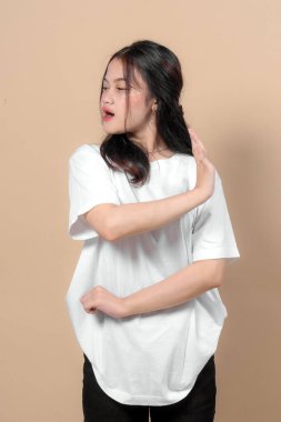 Asyalı kadın ciddi bir ifadeyle yüzünü çevirirken el hareketi yapıyor. Reddetme, tasvip etmeme, sınırlar veya kişisel reddetme kavramı.