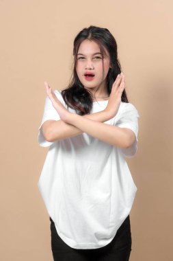 Asyalı genç bir kadın kolları ve yüzünde ciddi ifade ile 