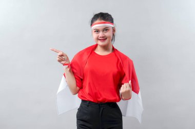 Kırmızı ve beyaz kıyafetli kendine güvenen Endonezyalı kız Bağımsızlık Günü 'nü mutlu ve enerjik bir gülümsemeyle kutluyor..