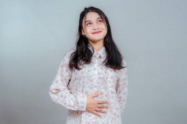 İnce bir gülümsemesi ve rüya gibi gözleri olan genç Asyalı bir kadın karnında bir eliyle yukarı bakıyordu. Onun sakin, düşünceli yüz ifadesi hayal gücünü, sıcaklığını ve sessiz neşesini yansıtıyor..