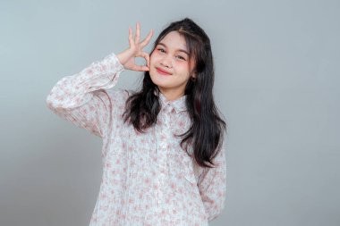 Neşeli, genç Asyalı bir kadın gözünün yanında 