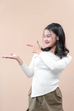 Gülümseyen Asyalı kadın açık avucuna neşeli bir ifadeyle bakıyor, sunumu, güveni ve iş, yaşam tarzı veya iletişim reklamlarını sembolize ediyor..