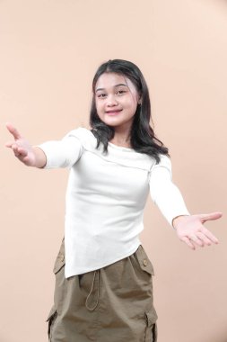 Kollarını açıp gülümseyen Asyalı kadın, sıcaklığını, dostluğunu ve bağlantısını ifade eden, güven, işbirliği, yaşam tarzı ve pozitif iletişim temalarına uygun,.