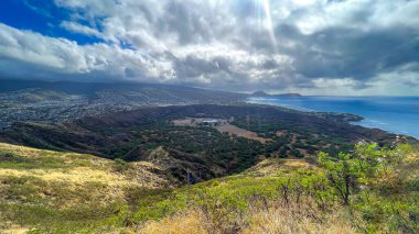 Honolulu landscape, The sky is very blue but covered in clouds you can see the shoreline And the city in the background clipart