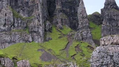 Yeşil yamacı olan bir dağ. Tepe çimlerle kaplı. Dağ sarp ve sarp.