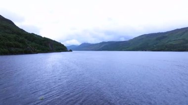 Üzerinde bulutlu bir gökyüzü olan bir su kütlesi. Su sakin ve berrak. Sahnede hiç insan ya da nesne yok.