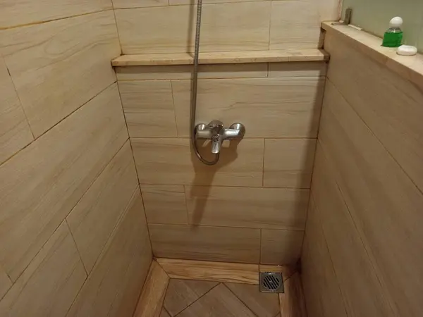 Duş başlığı ve tuvaleti olan bir banyo.