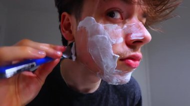 Siyah gömlekli ve saç tıraşlı genç adam.