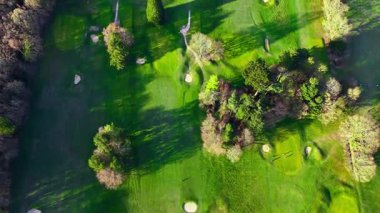Golf sahasında kuşların gözü baharda ağaçlarla çevrili rotada ilerliyor.