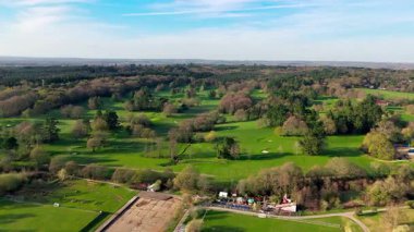 İngiltere 'deki golf sahasında, ilkbaharda doğa ve ağaçlarla çevrili aşağı bakan uzun bir saha var. 