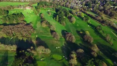 Golf sahası ağaçlarla dolup taşıyor. Havadan aşağıya inen ve ilkbaharda sola bakan ağaçlar.