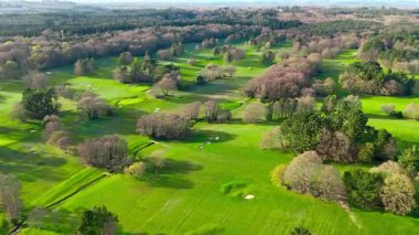 Baharda ağaçlarla çevrili devasa İngiliz Golf Sahası Hava Aracı Uçağı Görünümü