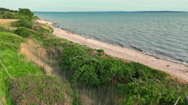 Hava statik çekimi, yeşillik ve kumsal ve okyanusla kaplı doğa ile İngiliz sahiline bakıyor.