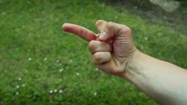 Orta parmak hareketi, arka planda beyaz erkek eli ile yüz yüze.