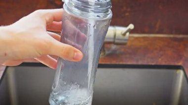 Mutfak lavabosunda Plastik Su Şişesini Yavaşça Doldurun