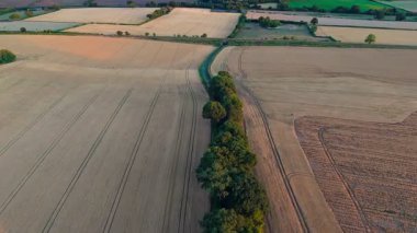 Yazın gün batımında çiftlikleri olan kırsal hava manzarası