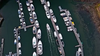 Günbatımında liman rıhtımında yelken açan teknenin ardından Havadan Kuşların Gözü Görünümü