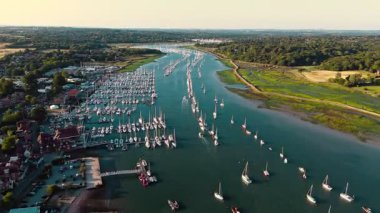 Limanda Hamble Nehri 'nin üzerinde, yazın günbatımında nehrin yukarısında rıhtıma bakan tekneleri olan insansız hava aracı.