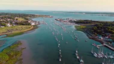 Hamble Marina Limanı 'nın hemen üzerinde, yazın günbatımında tekneleri nehre kenetlenmiş bir yüksek açı var.