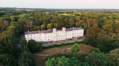 Hava durumu, yazın günbatımında ağaçlarla birlikte İngiltere 'nin doğadaki büyük beyaz köşkünü hızlı bir şekilde görüntüledi.
